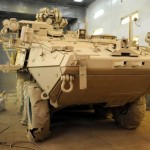 Jagadish Hajam, an auto body repairman and painter from Nepal, applies a coat of Tan 686A, a paint meant for desert camouflage, on the wheels of a Stryker armored combat vehicle inside a booth at Camp As Sayliyah, Qatar, Oct. 3. It's the first vehicle to adopt the new desert tan color in Southwest Asia, in preparation for a planned phase out of the Stryker's current deep green color.<br />Credits: Area Support Group Qatar Public Affairs Office, 10/3/09 Maintaining the Stryker