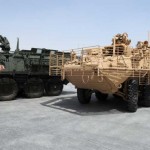 Dar Barker, a General Dynamics Land Systems retrofit chief from Puyallup, Wa., directs an armored combat vehicle outside the Stryker battle damage repair facility at Camp As Sayliyah, Qatar, Oct. 5. The Stryker infantry carrier vehicle had been restored after deterioration during enemy engagement in Iraq.<br />Credits: Area Support Group Qatar Public Affairs Office, 10/5/09 Repairing the Stryker