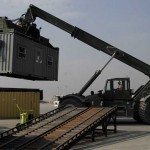 A civilian contractor, assists the 455th Expeditionary Aerial Port Squadron moving shipping containers Oct. 30. The 455th EAPS received multiple shipping containers, which can be used for anything from offices to living quarters. Instead of having the shipping containers sit on K loaders the Air Force, Army and civilian contractors teamed up and moved them to the Army's supply yard. <em>Credits: 455th Air Expeditionary Wing, 10/20/09, Location: Bagram Air Field, Afghanistan</em> Moving Containers