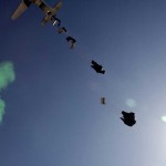 Bundles of bottled water attached to parachutes fall from an aircraft during an aerial resupply on Combat Outpost Herrera, Paktiya province, Afghanistan, Oct. 15, 2009. The green smoke was used as a visual marker for the pilots.<br /><em>Credits: Joint Combat Camera Afghanistan, 10/15/09, Location: Combat Outpost Herrera, Afghanistan</em> Water Delivery