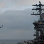 An MH-60S Knighthawk helicopter assigned to the "Wildcards" of Helicopter Sea Combat Squadron 23 flies around the island of the aircraft carrier USS Nimitz after transferring cargo from the fast combat support ship USNS Bridge during a replenishment at sea with Nimitz. The Nimitz Carrier Strike Group is on a routine deployment to the region. <br /> Credit USS Nimitz 10/1/09 MH-60S Knighthawk helicopter