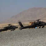 Two AH-64D helicopters warm up their engines prior to providing air support for Afghan commandos and coalition soldiers for an air assault mission from Forward Operation Base Airborne, Afghanistan, Sept. 28. <br />Credit: Joint Combat Camera Afghanistan 9/28/09 Two AH-64D helicopters