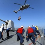 Sailors from the guided-missile destroyer USS Sampson stand by while an MH-60S Sea Hawk helicopter, assigned to the Wildcards of Helicopter Sea Combat Squadron 23, delivers supplies. Sampson is conducting a replenishment at sea with the Military Sealift Command fast combat support ship USNS Bridge. <br />Credit USN Visual News Service, 9/30/09 MH-60S Sea Hawk helicopter delivering supplies