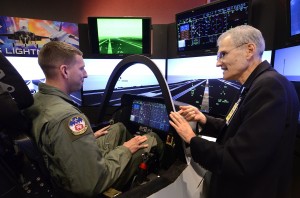 Senior Airman Michael Sterchi, a C-130 Loadmaster from the 700th Airlift Squadron, listens to Mr. Mike Skaff, chief engineer of pilot/vehicle interface for the F-35 program, for some pointers on flying an F-35C off the carrier, 31 Aug. Lockheed Martin held a special event for the press and invited guests at the Marietta facility with their F-35 Joint Strike Fighter cockpit demonstrator as the focal point. (U.S. Air Force photo/ Brad Fallin) 9/1/11