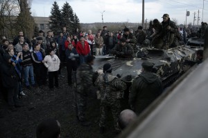 An armed man standing in front of a tank is believed to be pro-Russian as he's wearing the black ribbon of St. George, a symbol widely associated with pro-Russian protests in Ukraine. REUTERS/Maks Levin