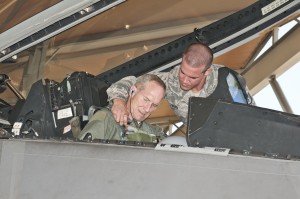U.S. Air Force Staff Sgt. Joshua Bard, a crew chief with the 43rd Aircraft Maintenance Unit, straps in Gen. Mike Hostage, commander of Air Combat Command, into an F-22 Raptor for his qualification flight at Tyndall Air Force Base, Fla. (U.S. Air Force photo by Christopher Cokeing/Released)