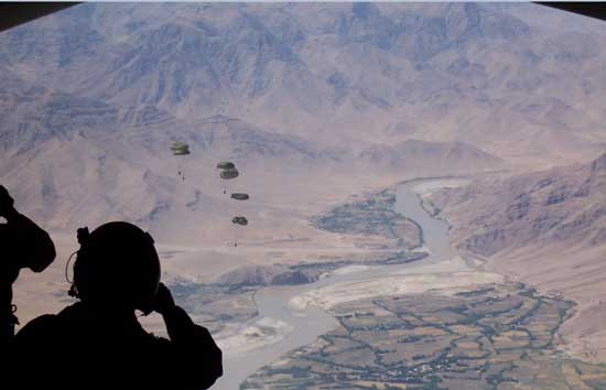 Staff Sgt. Derek Howard, 816th EAS evaluator loadmaster, watches cargo bundles fall over a drop zone in Afghanistan (Credit Photo: 379th Air Expeditionary Wing)